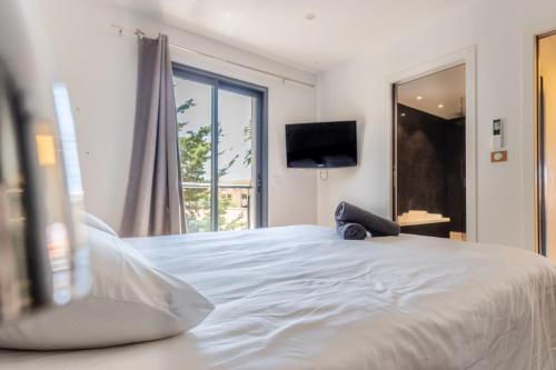 une chambre avec un grand lit blanc et une fenêtre dans l'établissement Maison villa Roof top vue mer jacuzzi, à Six-Fours-les-Plages