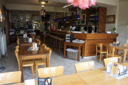 a restaurant with wooden tables and chairs and a bar at Alsput Hotel in Halle