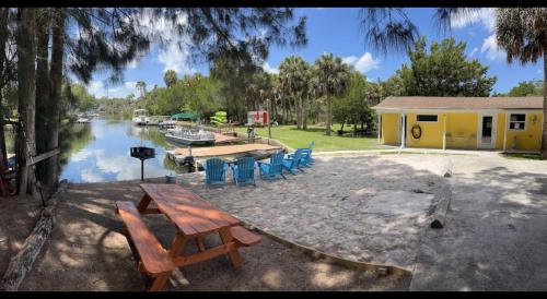 a picnic table and chairs in front of a house at Neptune's Grotto Old Florida Adventure Retreat in Spring Hill