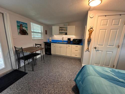 a bedroom with a bed and a table and a kitchen at Neptune's Grotto Old Florida Adventure Retreat in Spring Hill