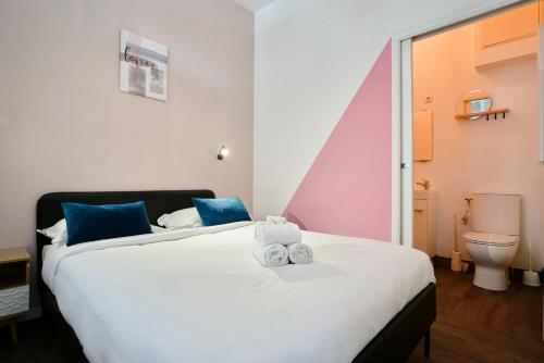 une chambre avec un grand lit avec des serviettes dessus dans l'établissement NG Prestige - Lille I Tourcoing Winoc - Appartement T2 - Netflix - Wifi - Cuisine - Parking gratuit, à Tourcoing