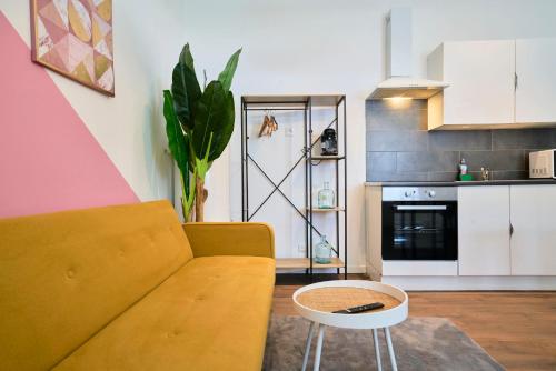 un salon avec un canapé et une table dans l'établissement NG Prestige - Lille I Tourcoing Winoc - Appartement T2 - Netflix - Wifi - Cuisine - Parking gratuit, à Tourcoing