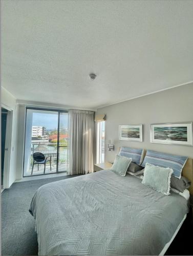 a bedroom with a large bed and a large window at Water View Retreat in Ballina
