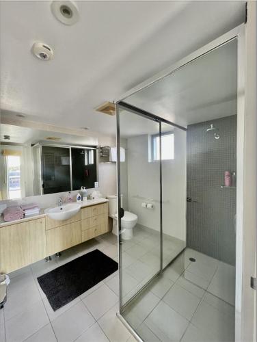 a bathroom with a glass shower and a sink at Water View Retreat in Ballina