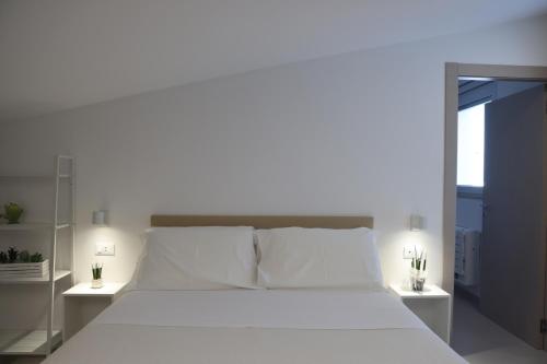 a bedroom with a white bed with white pillows at Ruffini Rooms in Termoli