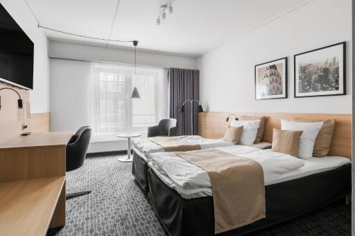 a hotel room with a large bed and a desk at Best Western Plus Hotel Odense in Odense