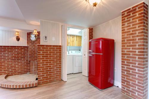 a red refrigerator in a room with a brick wall at 4 Beds Entire House Wifi Parking in Laval-des-Rapides