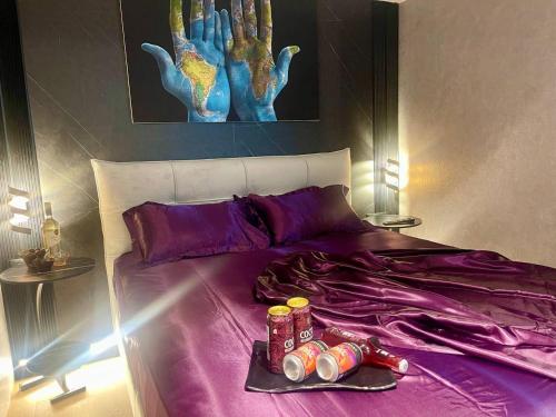 a purple bed with a tray of drinks on it at C Tower Premium Apartments, Panoramic Sea View in Netanya