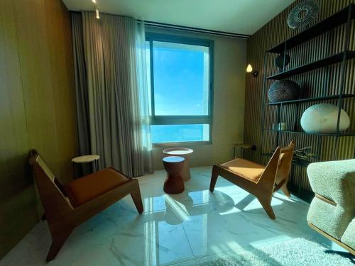 a living room with a couch and chairs and a window at C Tower Premium Apartments, Panoramic Sea View in Netanya