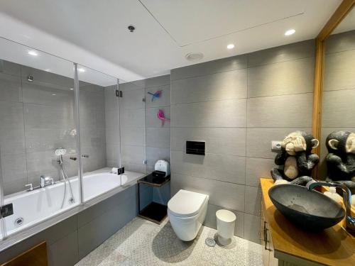 a bathroom with a tub and a toilet and a sink at C Tower Premium Apartments, Panoramic Sea View in Netanya