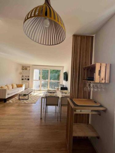 un salon avec une table et un grand éclairage dans l'établissement Appartement cosy proche Paris, à Clamart