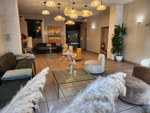 a living room with couches and chairs and a table at Hôtel Abalone - Centre Gare in Nîmes