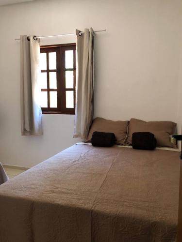 a large bed in a bedroom with a window at Casa Mobiliada próximo do restaurante Bosque da Serra in Santa Fé