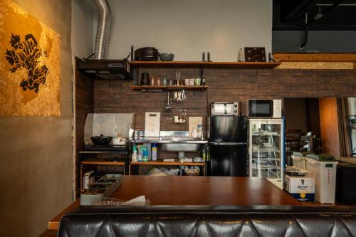 a kitchen with a table and a refrigerator at アワセベイストリートホテル in Okinawa City