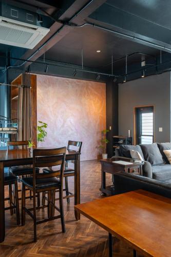 a living room with wooden tables and a couch at アワセベイストリートホテル in Okinawa City