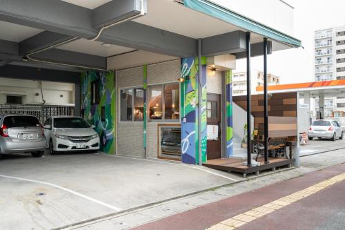 a gas station with cars parked outside of it at アワセベイストリートホテル in Okinawa City