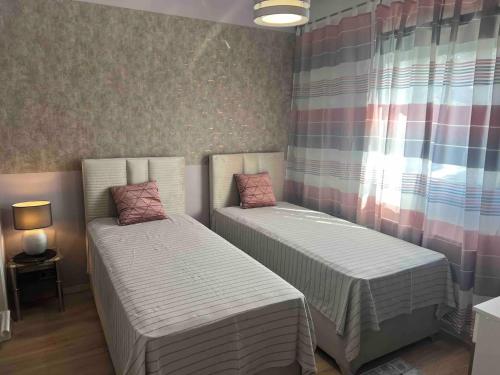 a small room with two beds and a window at Appartements Bel Lago Bestensee in Bestensee