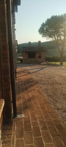 a brick sidewalk next to a building with a tree at ElsAnto-beb in San Venanzo