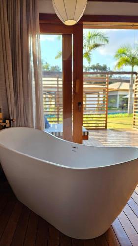 a large white bath tub in a room with a window at Tiradentes Boutique Hotel in Tiradentes