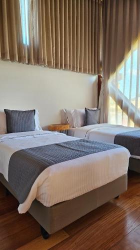 a bedroom with two beds and a window at Tiradentes Boutique Hotel in Tiradentes