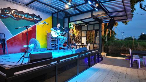 a stage with a man playing a guitar on it at The Great Residence Suvarnabhumi Airport in Lat Krabang