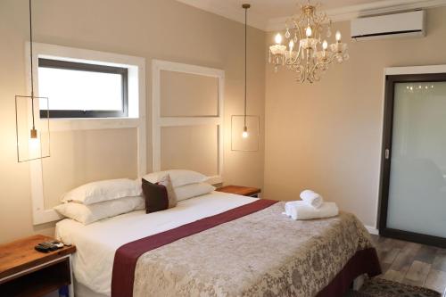 a bedroom with a bed and a chandelier at Boutique Guesthouse Mariental in Mariental
