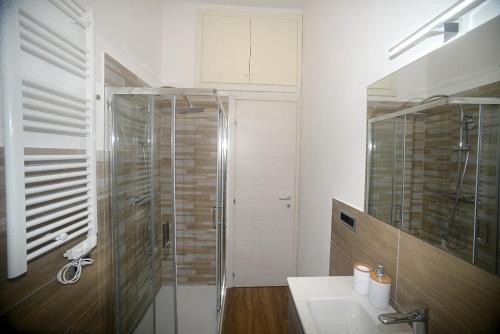 a bathroom with a glass shower and a sink at Casa Parisina in Chianciano Terme