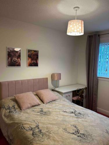 a bedroom with a bed with two pillows on it at 15 min drive to airport 20 min to Loch Lomond and city center in Old Kilpatrick