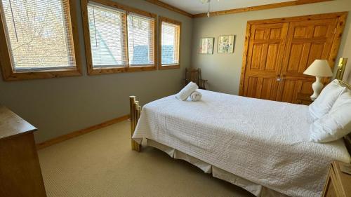 a bedroom with a white bed and windows at Victory Gardens in Union Pier