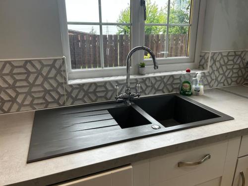 a kitchen sink with a faucet on top of it at 15 min drive to airport 20 min to Loch Lomond and city center in Old Kilpatrick