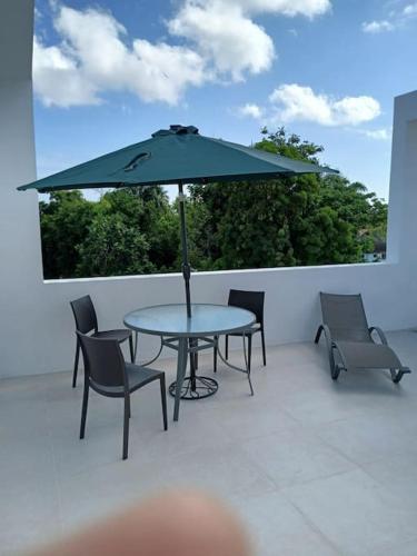 a table and chairs and an umbrella on a patio at En Plaza Center Penthouse con 3 terrazas en el centro de Las Terrenas la playa està a 5 min a pied in Las Terrenas