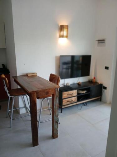 a living room with a wooden table and a flat screen tv at En Plaza Center Penthouse con 3 terrazas en el centro de Las Terrenas la playa està a 5 min a pied in Las Terrenas