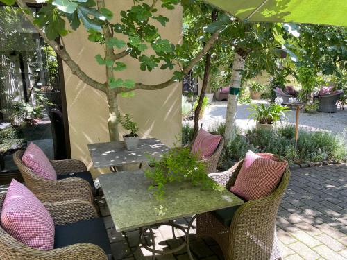 an outdoor table and chairs with an umbrella at Jugendstil-Hof in Langenlonsheim