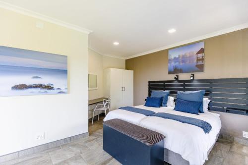 a bedroom with a large bed with blue pillows at 8 On Eagle Bed & Breakfast Room 1 in Umtentweni