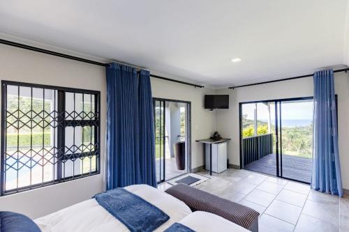 a living room with a bed and a balcony at 8 On Eagle Bed & Breakfast Room 1 in Umtentweni