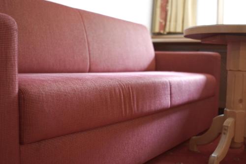 a red couch sitting next to a table at Hotel Alpina in Ischgl
