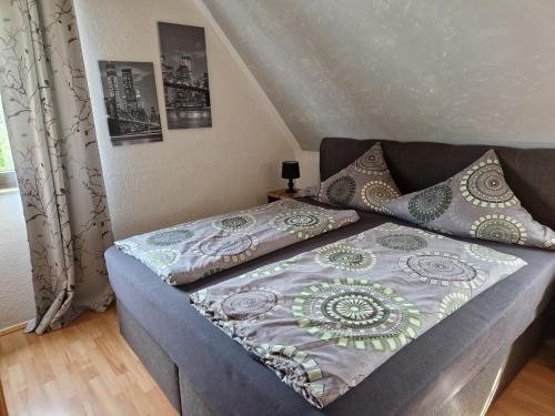 a bed with a quilt on it in a bedroom at Ferienwohnung Parkblick Medebach - wunderschöne 52qm Dachterasse - in der Nähe von Center Parcs in Medebach