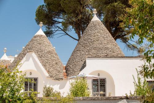 a white house with two steep roofs at I Trulli e la Luna in Alberobello