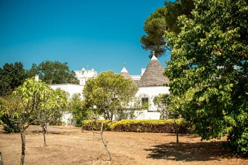 a white house with trees in front of it at I Trulli e la Luna in Alberobello