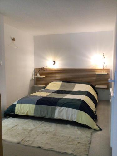 a bedroom with a bed with a striped comforter at Appartement avec jardin in Perpignan