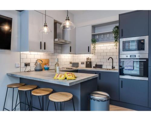 a kitchen with a large counter with stools at Bliss Stay Belfast University Street in Belfast