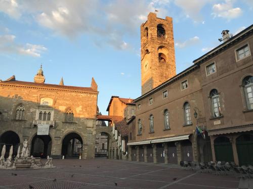 a building with a clock tower in a city at La Torta Di Mele in Bergamo