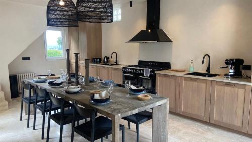 une grande cuisine avec une table en bois et des chaises dans l'établissement Villa de charme avec grand jardin centre Trouville sur mer, à Trouville-sur-Mer