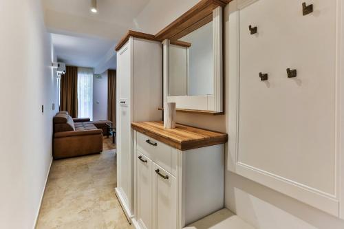 a kitchen with white cabinets and a living room at Luxury Apartments Przno in Budva