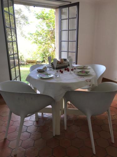d'une table blanche avec deux chaises et d'une table blanche avec un siège. dans l'établissement Chambre d'hôte la Croix St François GRASSE, à Saint-Marc