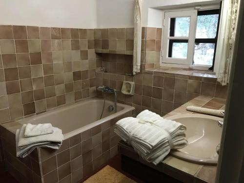 La salle de bains est pourvue d'une baignoire, d'un lavabo et de serviettes. dans l'établissement Chambre d'hôte la Croix St François GRASSE, à Saint-Marc