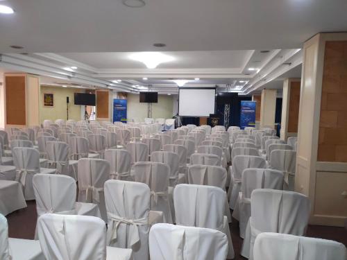 an empty room with white chairs and a projection screen at Grand Hotel Mosè in Villaggio Mosè