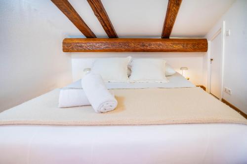 une chambre avec un lit avec des draps blancs et des oreillers dans l'établissement Le Hameau de Taconnaz - Calme - Charme, aux Houches