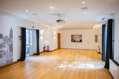 an empty room with a hardwood floor and large windows at Domaine de la Tortinière in Montbazon
