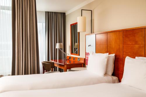 a hotel room with two beds and a desk at Holland House Hotel Cardiff By Sunday in Cardiff